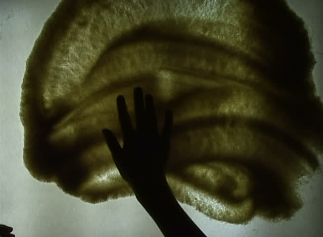 the hand draws a bicycle silhouette on a sandy surface  