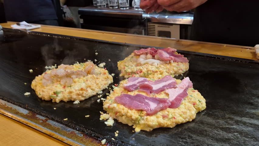 Hot freshly cook okonomiyaki Japanese style pizza on hot plate Osaka street food