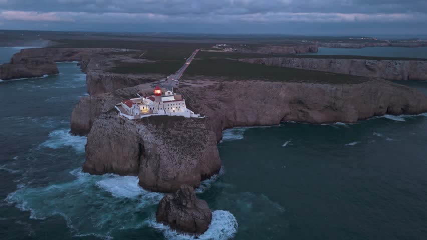 Cape Saint Vincent, Lighthouse, Cliffs and Atlantic Ocean at Night. Aerial View. Sagres, Algarve, Portugal. Orbiting