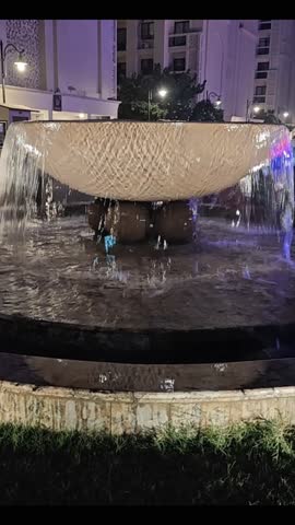 Vertical night fountain video with cascading water and architectural lighting—ideal for luxury real estate, hotel promos, travel reels, and urban ambiance. Captures serene motion, elegant design, and cinematic cityscape aesthetics.