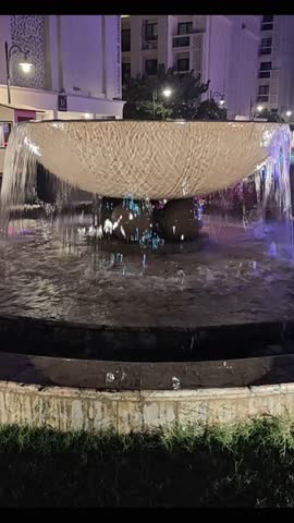 Vertical night fountain video with cascading water and architectural lighting—ideal for luxury real estate, hotel promos, travel reels, and urban ambiance. Captures serene motion, elegant design, and cinematic cityscape aesthetics.