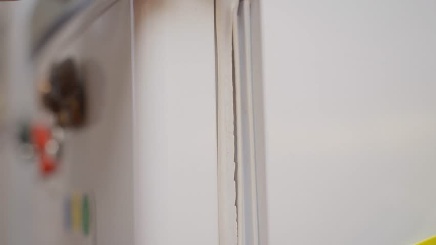 The sealing rubber on the refrigerator door is torn, close-up