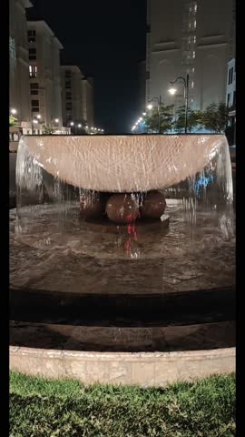 Vertical night fountain video with cascading water and architectural lighting—ideal for luxury real estate, hotel promos, travel reels, and urban ambiance. Captures serene motion, elegant design, and cinematic cityscape aesthetics.