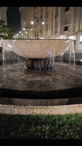 Vertical night fountain video with cascading water and architectural lighting—ideal for luxury real estate, hotel promos, travel reels, and urban ambiance. Captures serene motion, elegant design, and cinematic cityscape aesthetics.
