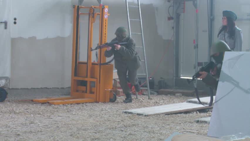 Female officer training with soldiers in warehouse