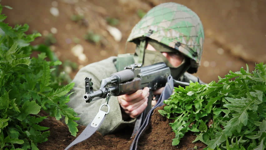 Soldier in cover aiming with AK-47