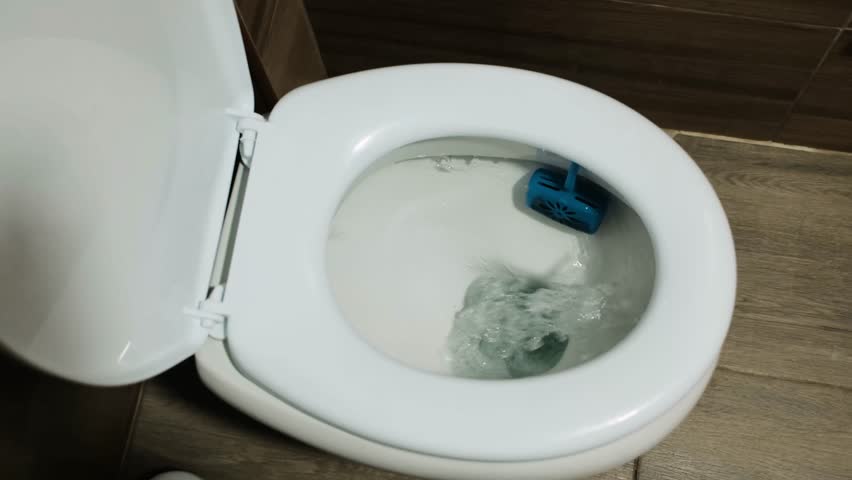 Toilet flushing with clear water movement in a modern bathroom interior. Clean sanitation process, hygiene concept, household plumbing and everyday restroom use. Horizontal 4k footage