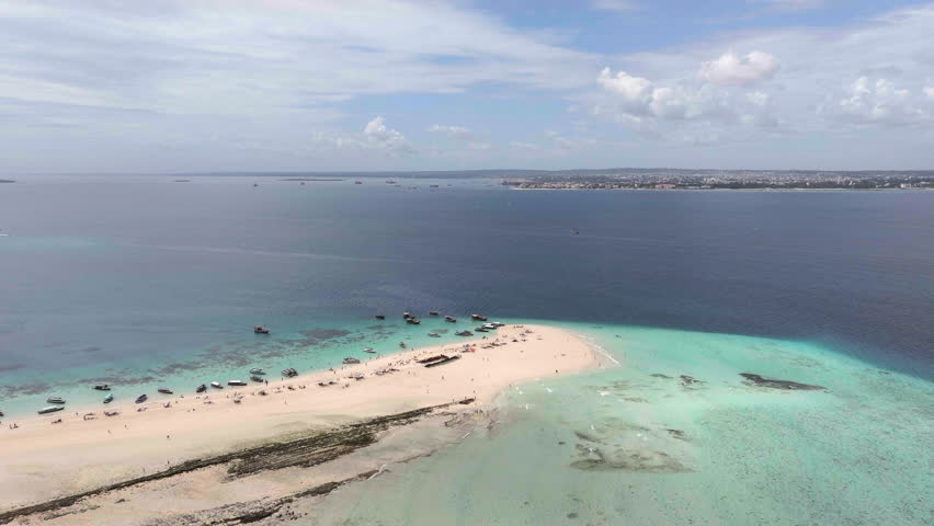 Aerial view of Nakupenda island, sandbank in ocean, white sand, boats, yachts, blue sea during low tide at sunny summer day in Zanzibar.Top view of sand spit, clear water and sky.