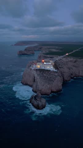 Cape Saint Vincent, Lighthouse, Cliffs and Atlantic Ocean at Night. Aerial View. Sagres, Algarve, Portugal. Moving Forward. Vertical Video