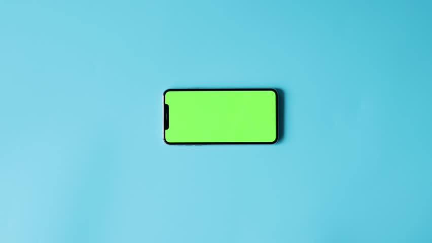 Smartphone with Green Screen on Blue Background. Concept mockup and green blank on phone for advertising on light background