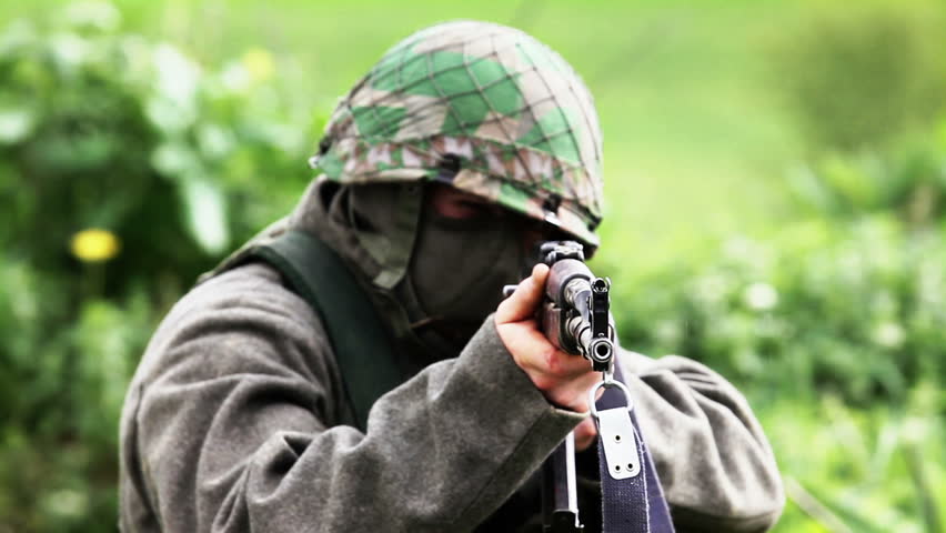Soldier aming close at camera with AK-47
