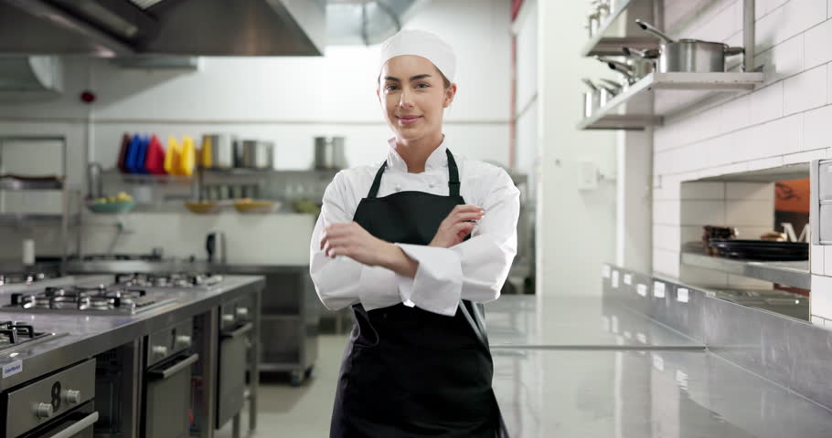 Face, chef and happy woman with arms crossed in kitchen for catering, gastronomy or pride. Portrait, smile and culinary artist with confidence in restaurant, professional cook or hospitality in Italy