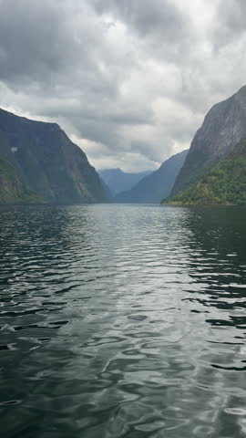 Navigating a scenic norwegian fjord under a cloudy sky