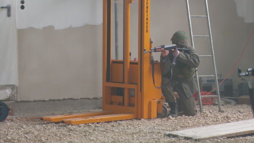 Femaile officer training with soldiers in warehouse