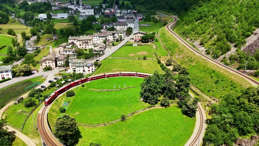 Drone Switzerland 4k.  train on way to St. Moritz. Brusio spiral viaduct, stone spiral railway viaduct on the Bernina Railway. Swiss Alps in summer. 