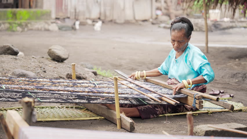 A woman on flores island hand weaving fabric with pattern, indonesian people and culture, indonesia