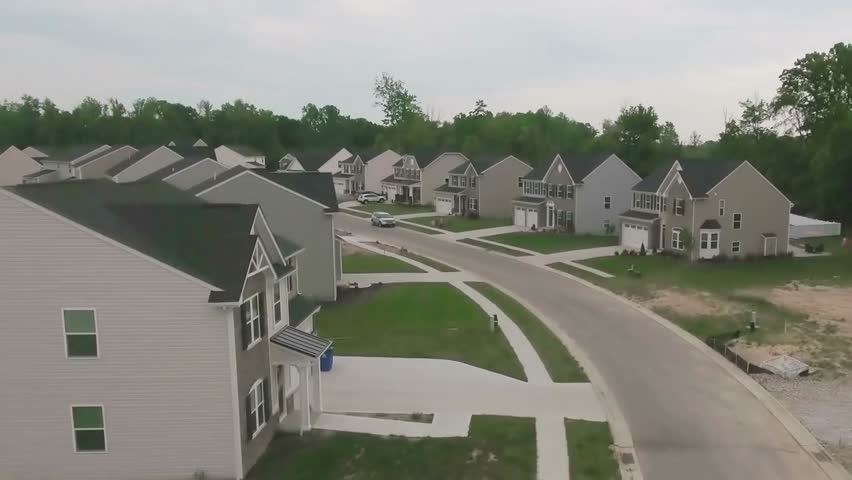 Aerial view of a typical Ohio neighborhood, showing houses, streets, and greenery in a slow, smooth cinematic motion.