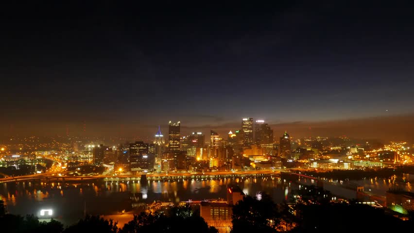 Dramatic time-lapse of Pittsburgh transitioning from night to day, capturing sunrise, cityscape, and urban skyline.