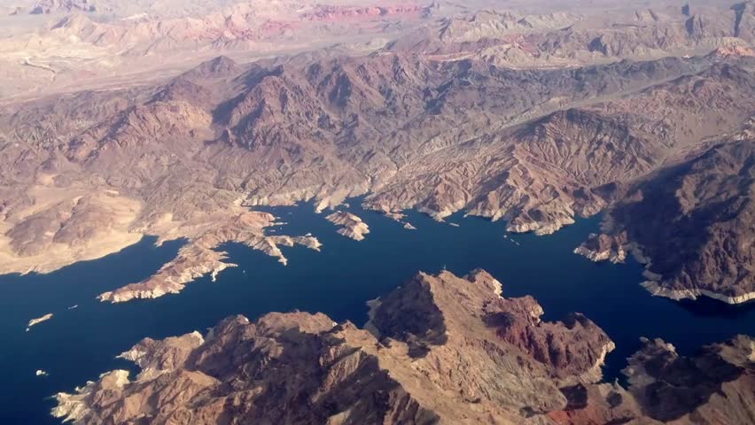 Aerial view flying over Lake Mead, capturing expansive water, surrounding desert landscapes, and natural beauty from above.