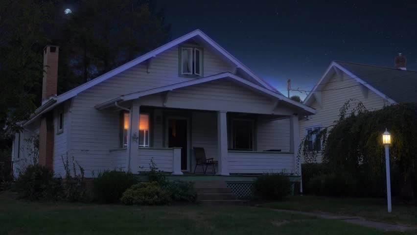 Night or dusk wide shot of a typical Middle-Class New England home in Pittsburgh suburbs, lights switching on off, moon in distance, residential scene.