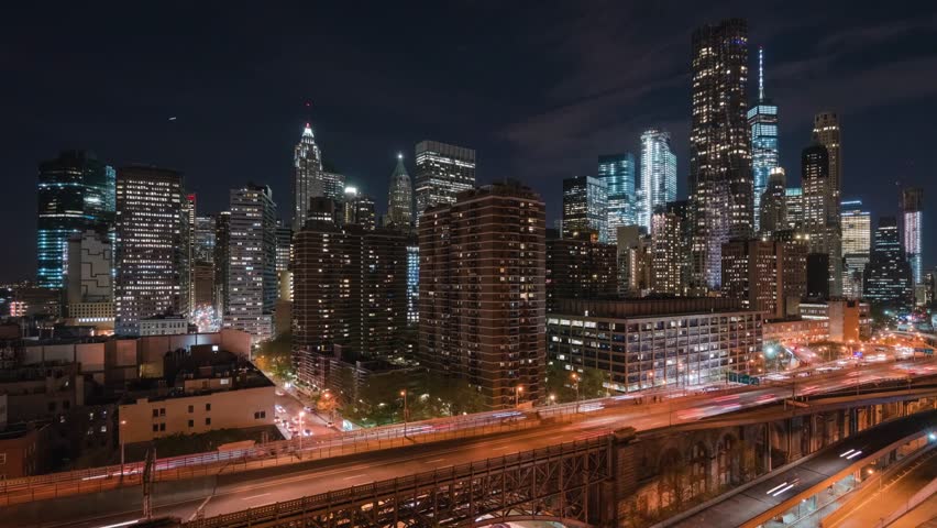 City skyline glowing at night with moving traffic lights.