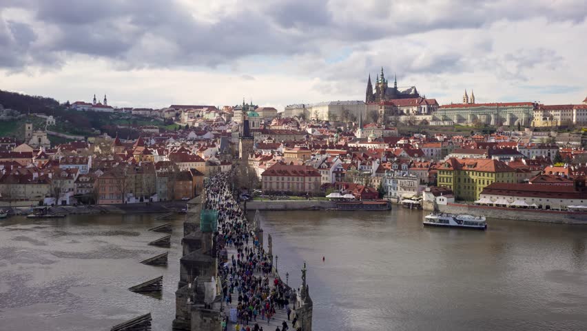 Crowded Charles Bridge crossing the river in Prague city.