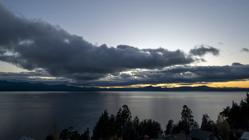 Peaceful lake scene at sunset with trees and mountains