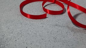 Footage of a red satin awareness ribbon curling slowly on a grey textured background. Ideal for World AIDS Day, heart health, and social solidarity - Powered by Shutterstock - Get 15% off with code: PIKWIZARD15
