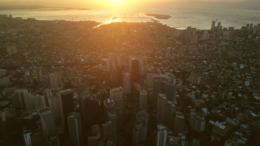 Aerial view of skyscrapers buildings in Makati business district and Manila city at sunset, capital of Philippines, panorama 4k