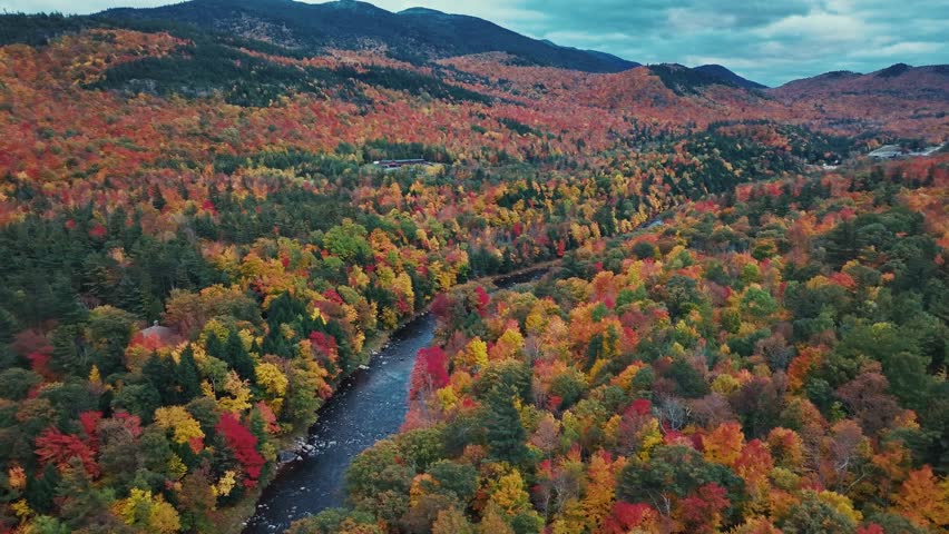 Adirondack Mountain, New York State. Aerial view of autumnal forest landscape with river and mountains in the background.