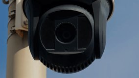 Close-up of a round black surveillance camera mounted on a white pole, with sky in the background, highlighting modern security technology and monitoring. - Powered by Shutterstock - Get 15% off with code: PIKWIZARD15