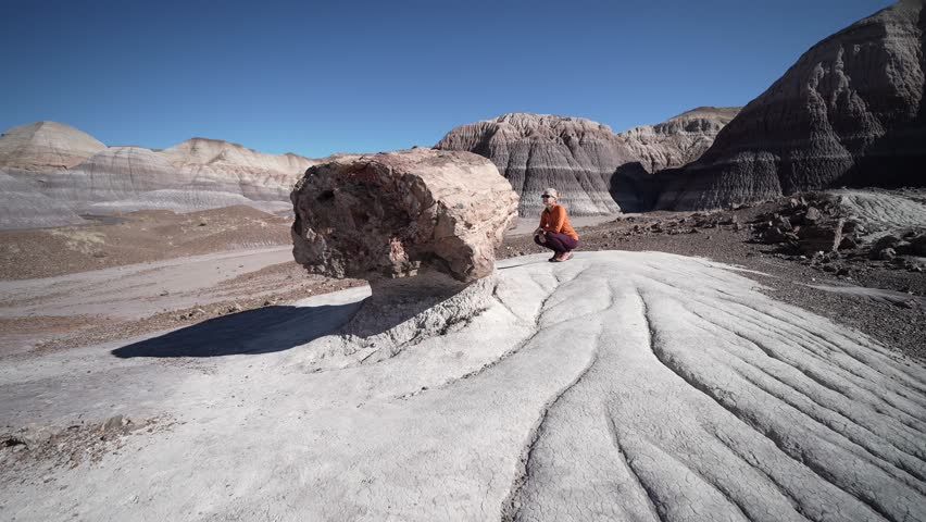 Hiker explores the unique landscape of Blue Mesa while enjoying the scenery in Petrified Forest National Park in Arizona.