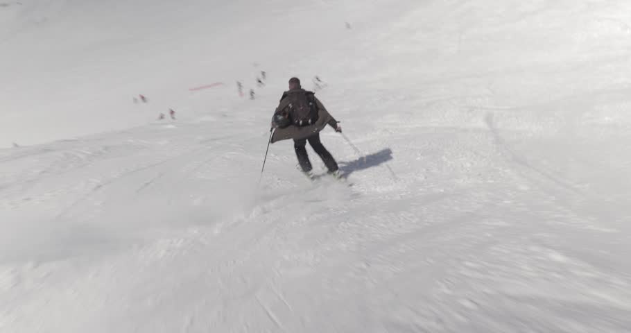 Skiing in the Alps, skier going fast descend, dynamic follow shot on slowy slopes
