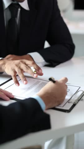 Lawyers signing contract and shaking hands after successful agreement.