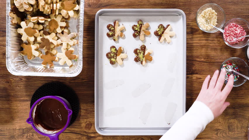 Flat lay. Preparing star-shaped cookies, half-dipped in chocolate, accented with peppermint chocolate chips for the holidays.
