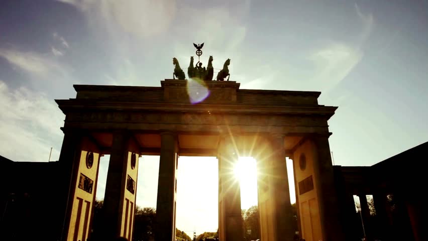 Iconic Brandenburg Gate stands tall against a vibrant sunset, showcasing detailed architecture and a serene cityscape. Perfect for travel and historical themes.