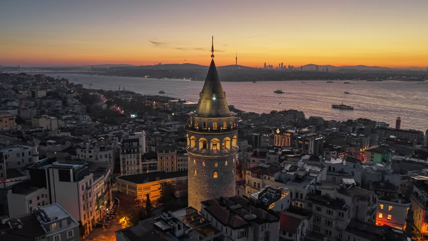 Galata Tower illuminated against the red morning sky, Istanbul, Turkey. Aerial view of Galata Tower and Istanbul skyline at sunrise over the Bosphorus. UHD HDR shot 