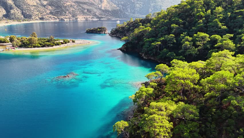 Flying over blue lagoon in Oludeniz. Stunning blue waters and peaceful beaches of Oludeniz in Turkey during sunny afternoon. Best travel destinations in Turkey, aerial shot