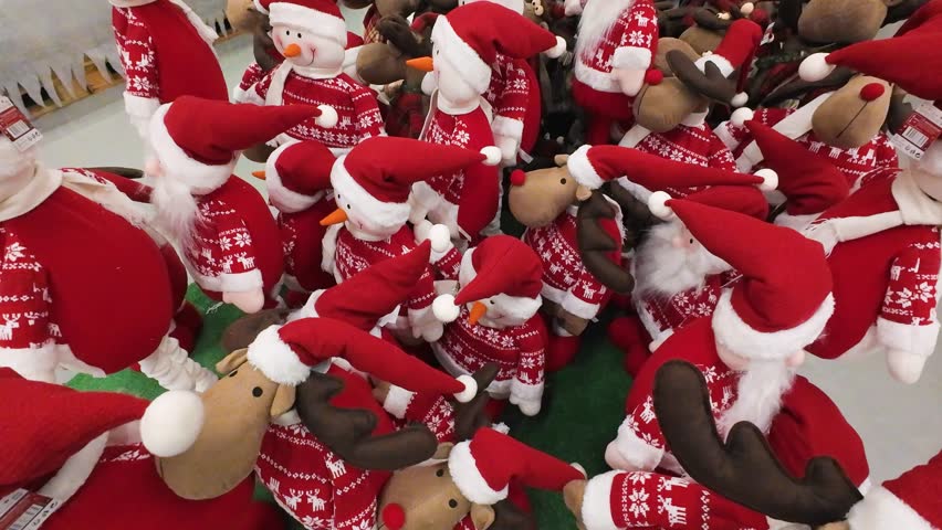 Christmas decorations for sale in a shopping mall. Festive holiday display featuring snowmen and reindeer plush toys. Seasonal shopping atmosphere in a retail store.