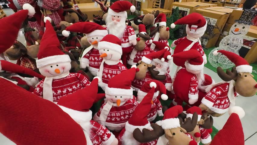Christmas decorations for sale in a shopping mall. Festive holiday display featuring snowmen and reindeer plush toys. Seasonal shopping atmosphere in a retail store.