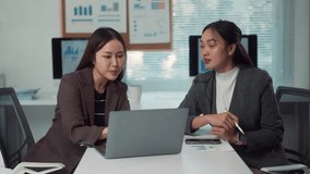 Two enthusiastic female colleagues brainstorming and discussing a financial business project using a laptop in a modern office environment - Powered by Shutterstock - Get 15% off with code: PIKWIZARD15