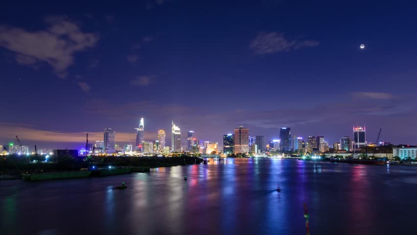 Night skyline of Saigon city with river reflections and lights.