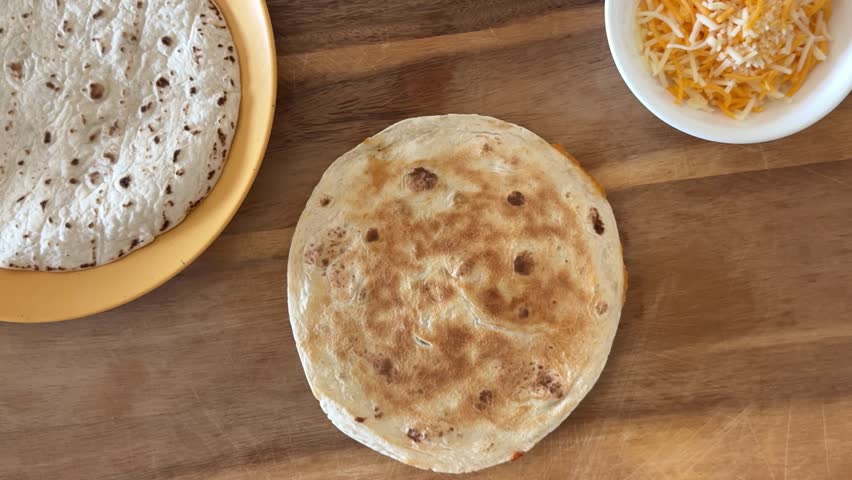 Cutting a Cheese Quesadilla with Flour Tortillas and Cheese Shot From Above