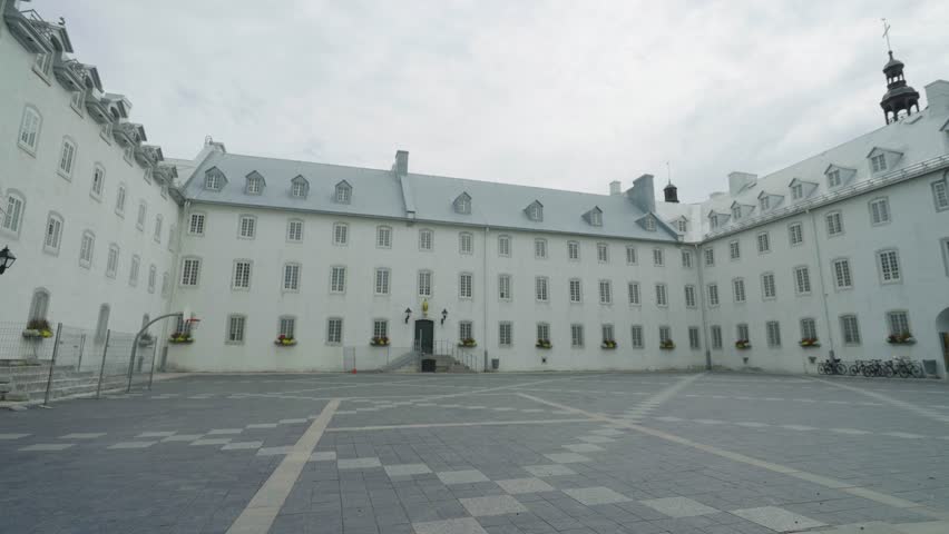 Historic Quebec City building with serene empty courtyard and cloudy sky