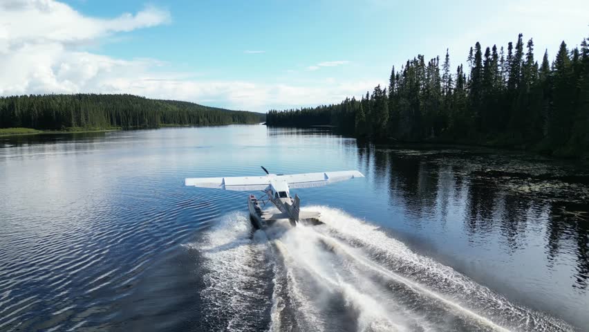 Seaplane takes off from serene lake in Quebec, surrounded by forest
