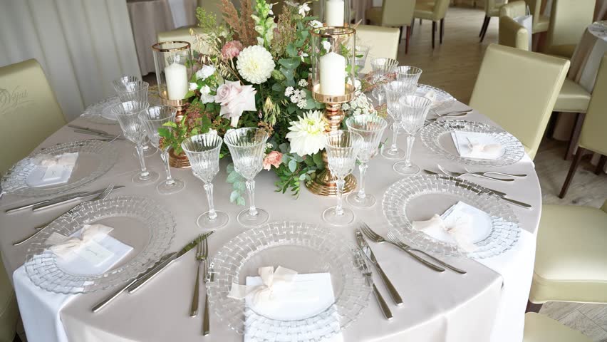 Explore a sophisticated wedding table setup featuring luxurious floral centerpiece, crystal glassware, and exquisite tableware. Captured in soft, natural light for an elegant ambiance.