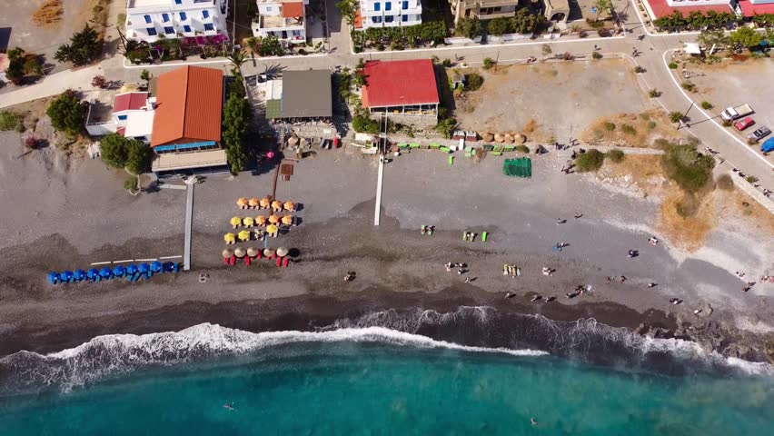Overhead view of wonderful beach in Southern Crete with turquoise waves breaking on dark sand shores of Agia Roumeli - Crete, Greece