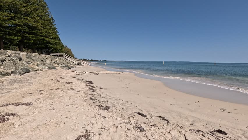 Busselton Beach and Geographe Bay on calm sunny day, pan right clip
