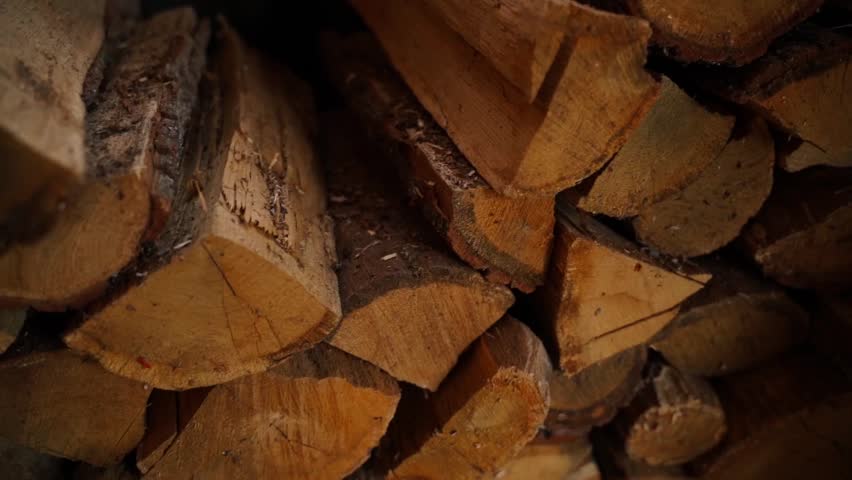 Smooth camera movement near chopped oak firewood for heating the house, close-up