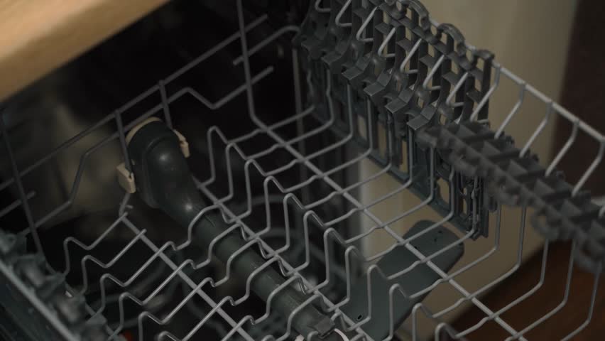 The process of stacking cups in the dishwasher, close-up. Cleaning dirty dishes